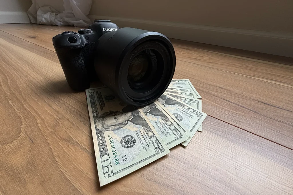 A professional camera resting on a pile of cash, symbolizing the cost factors behind event photography pricing.