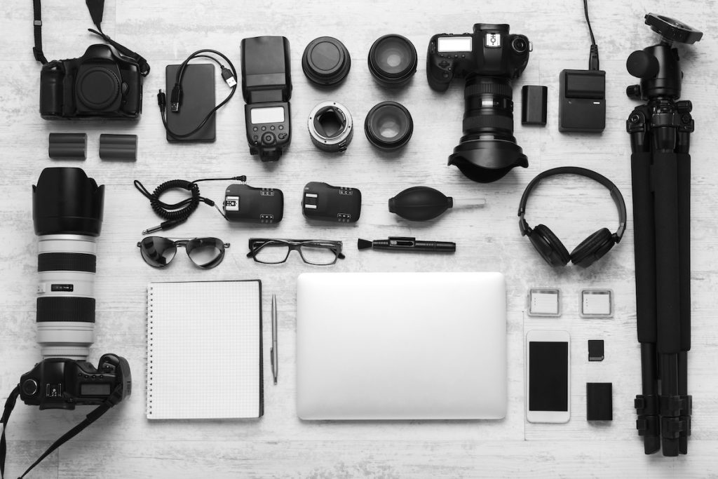 A large variety of professional event photographer equipment on a table.